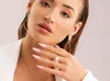A close-up shot of a woman's face and hand, showcasing makeup and jewelry. Náhled obrázku produktu