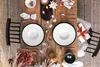 A beautifully set dining table with two place settings, complete with plates, cutlery, glasses, candles, and decorative elements, suggesting a festive or special occasion. Produktbild-Vorschau