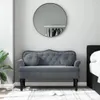 A dark gray velvet bench with tufted cushions and decorative studs sits in a room with a large round mirror on the wall. Náhled obrázku produktu