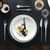 A beautifully set table with a plate of food, cutlery, and glasses. Voir les images du produit