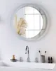 A modern bathroom sink area with a round mirror above it. Náhled obrázku produktu