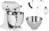 A white KitchenAid stand mixer with various attachments and a separate mixing bowl are displayed against a white background. Podgląd zdjęcia produktu