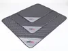 Three stacked gray quilted dog mats of different sizes, each with a light gray band and a logo. Náhľad obrázku produktu