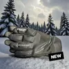 A pair of black ski gloves resting on snow with a winter forest in the background. Produktbild-Vorschau