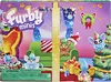 A festive, Christmas-themed scene depicting Furby Minis toys in a cozy living room setting with a Christmas tree, presents, and a couch. Náhled obrázku produktu
