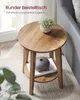 A round side table with a plant and a vase on it, placed next to a sofa. Produktbild-Vorschau