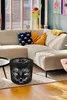 A living room scene with a sectional sofa, decorative pillows, a vase of flowers, and a black cat-themed pouf in the foreground. Produktbild-Vorschau