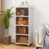 A tall, white storage cabinet with four transparent drawers filled with various items, placed next to a sofa and a potted plant. Náhľad obrázku produktu