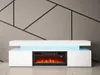 A modern white TV stand with a built-in electric fireplace and blue LED lighting, set against a gray wall with a geometric pattern. Náhľad obrázku produktu
