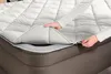A person's hands are shown zipping up a mattress topper onto an air mattress. Produktbild-Vorschau