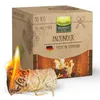 A box of wood wool firelighters with a burning firelighter in the foreground. Produktbild-Vorschau