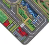 A close-up view of a colorful children's play rug depicting a town with roads, buildings, a soccer field, and parking spaces. Produktbild-Vorschau