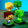 Four Minecraft-themed character lamps are displayed on a checkered surface against a blue background. Produktbild-Vorschau