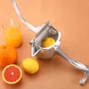 A manual juicer with citrus fruits and juice on a wooden surface. Náhľad obrázku produktu