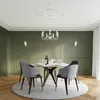 A dining room with a chandelier, a round dining table with chairs, and decorative wall paneling. Voir les images du produit