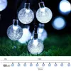 A string of solar-powered LED lights with clear, bubble-like bulbs, shown both in a close-up and with a diagram indicating length and LED count. Produktbild-Vorschau