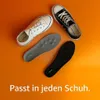 Zwei OMNIHEAL-Einlegesohlen, eine graue und eine schwarze, neben einem weißen und einem schwarzen Canvas-Schuh auf orangefarbenem Hintergrund Produktbild-Vorschau