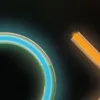 A close-up of a neon-colored gaming rug with a blue and green circular pattern on the left and an orange diagonal line on the right, against a black background. Podgląd zdjęcia produktu