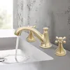 A gold-colored faucet with water running into a white sink. Podgląd zdjęcia produktu