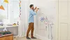 A man is drawing on a whiteboard in a child's room. Podgląd zdjęcia produktu