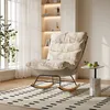 A cozy living room scene featuring a rocking chair, a small side table with decorative items, and a large window with sheer curtains. Náhľad obrázku produktu