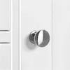 A close-up of a silver doorknob on a white cabinet door. Produktbild-Vorschau