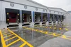 A row of loading docks at a warehouse with yellow markings on the wet concrete floor. Náhľad obrázku produktu