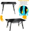 Two images of a black foldable camping table, one showing the table at a higher setting and another at a lower setting. There is also a close-up inset showing the height adjustment mechanism. Produktbild-Vorschau
