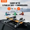 A car roof rack loaded with skis and snowboards, with people in the background on a snowy mountain. Produktbild-Vorschau