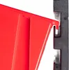 A close-up view of a red storage bin hooking onto a black wall-mounted organizer. Náhled obrázku produktu