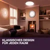 A living room with a sofa, fireplace, and decorative lighting. Produktbild-Vorschau