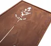 A close-up view of a metal garden screen with a cut-out design of a plant stem and leaves, showing its rusted texture. Podgląd zdjęcia produktu