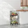 A three-tiered kitchen trolley filled with fruits and vegetables, placed on a tiled floor next to kitchen cabinets and a window with blinds. Anteprima dell’immagine prodotto