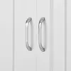 A close-up view of two silver cabinet handles on white doors. Anteprima dell’immagine prodotto