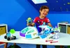 A young boy is playing with a Toy Story 4 Buzz Lightyear's Star Command spaceship playset in a room. Produktbild-Vorschau