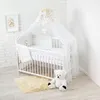 A baby crib with bedding and a teddy bear. Anteprima dell’immagine prodotto