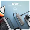 A laptop connected to a USB-C hub which is plugged into a power adapter, illustrating power delivery charging. Produktbild-Vorschau