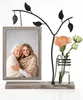 A decorative picture frame with a metal tree branch design, holding a photo of two women and a small vase with flowers. Produktbild-Vorschau