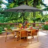 An outdoor patio scene with a table and chairs set up under a large gray umbrella. Produktbild-Vorschau