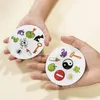 Two hands holding circular cards with various cartoon images. Voir les images du produit