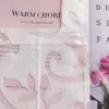 A close-up view of a white sheer curtain with a floral cut-out pattern, layered over a pink background with text. Pink roses are visible on the right side. Produktbild-Vorschau