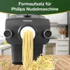 A Philips pasta maker attachment with fresh pasta coming out of it, placed on a wooden surface. Produktbild-Vorschau