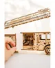 A close-up of a wooden model fire truck with a ladder extended, showing intricate details and a hand opening a compartment. Produktbild-Vorschau