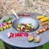 A grill fire pit with various food items prepared for grilling, set against a stone wall background. Anteprima dell’immagine prodotto