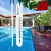 A pool thermometer hanging next to a swimming pool with a resort-like house in the background. Produktbild-Vorschau