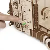 A finger is shown pressing a lever on a wooden model truck. Podgląd zdjęcia produktu