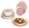 A set of pink and white ceramic tableware, including plates and bowls, with a bowl of soup and meatballs in the foreground. Podgląd zdjęcia produktu