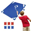 A boy is playing a cornhole game with a blue board and bean bags. Podgląd zdjęcia produktu