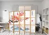 A room divider with Japanese-style artwork is set up in a room with a desk and shelving unit. Produktbild-Vorschau
