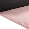 A close-up view of the underside and edge of a pink rug, showing its texture and backing. Produktbild-Vorschau